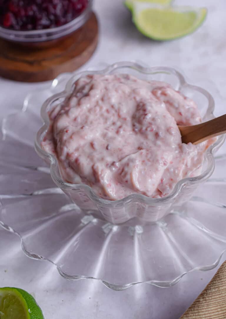 A bowl of cranberry mayonnaise with more cranberry sauce in the back.