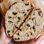 A hand is holding the cut in half bread.