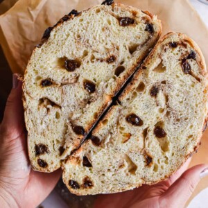 A hand is holding the cut in half bread.