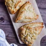 Three scones are on a cutting board.
