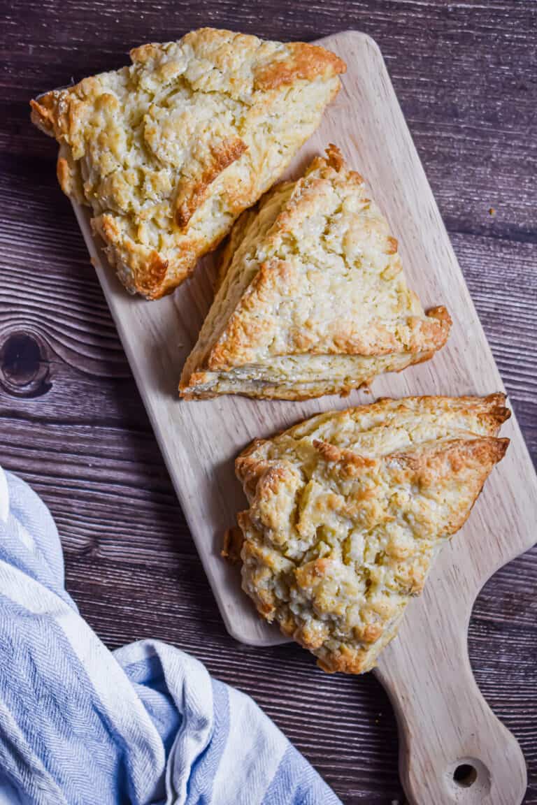 Three scones are on a cutting board.