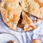 A piece of apple pie is cut out of the larger pie.