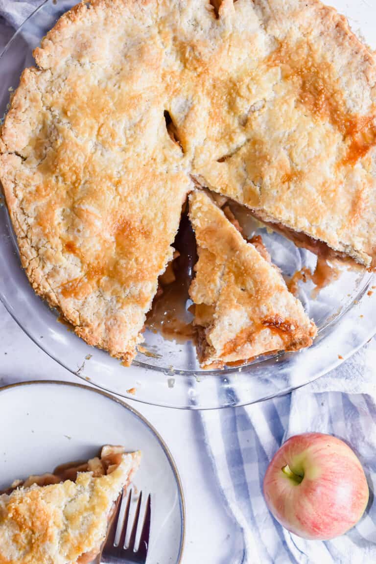 A piece of apple pie is cut out of the larger pie.