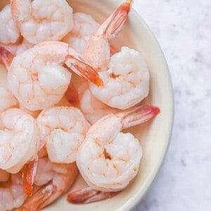 A bunch of shrimp are on an oval, yellow plate