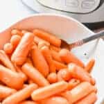 The Instant Pot is behind the bowl of carrots.
