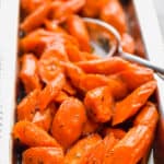 A spoon is in the carrots.