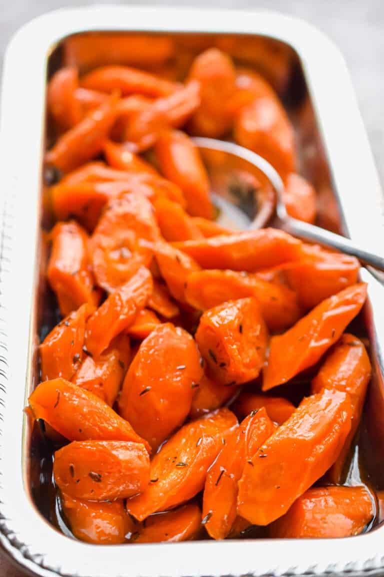 A spoon is in the carrots.
