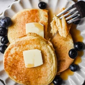 A fork is holding a piece of the pancakes