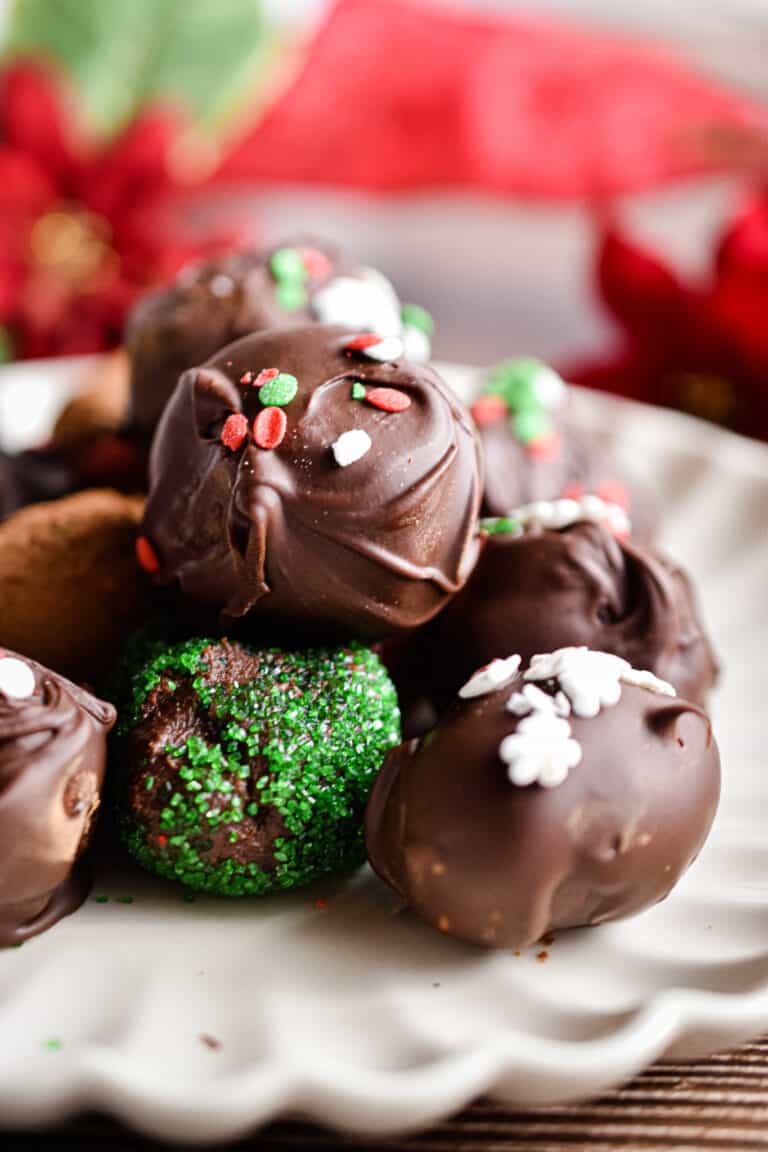 A pile of chocolate truffles on a fluted plate.