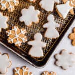 Snowflakes and gingerbread women are decorated on baking sheets.