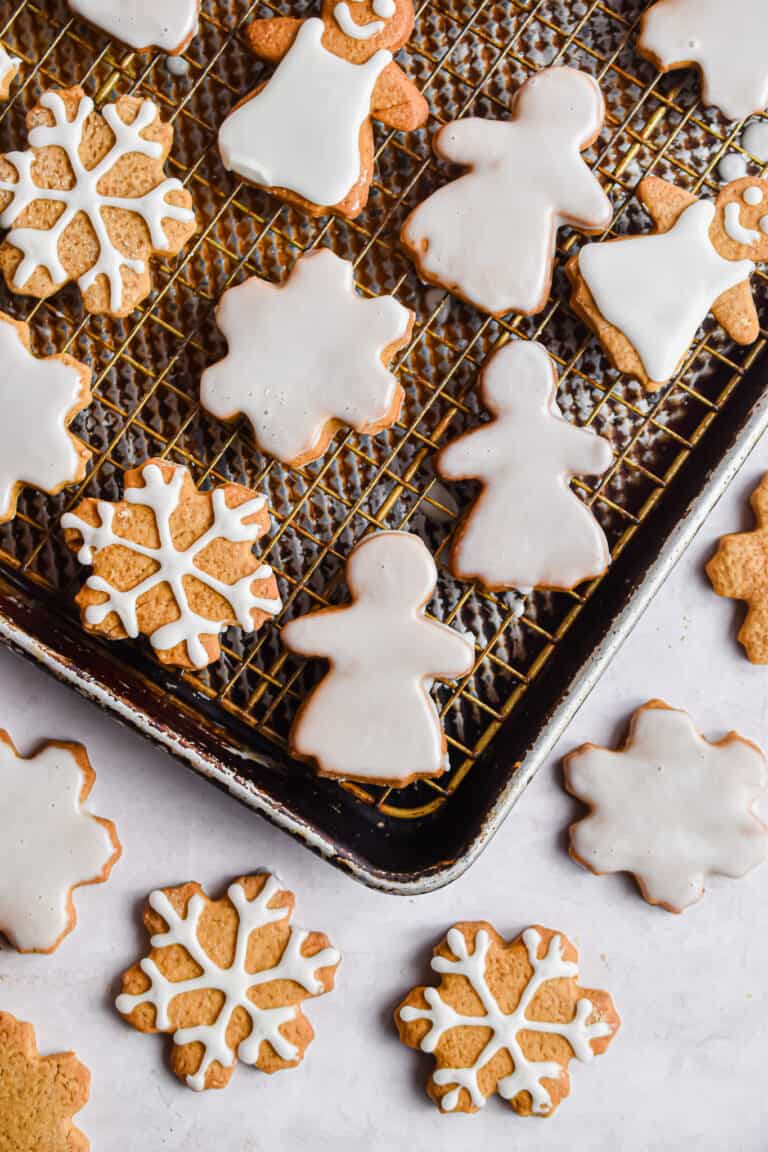 Snowflakes and gingerbread women are decorated on baking sheets.