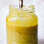 A spoon is sticking out of a mason jar with 2 ingredient honey mustard.