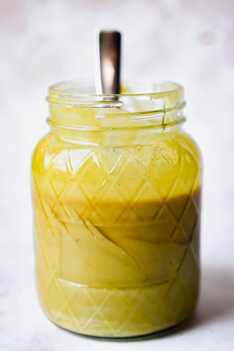 A spoon is sticking out of a mason jar with 2 ingredient honey mustard.