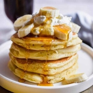 the 4 ingredient banana pancakes are stacked and topped with whipped cream