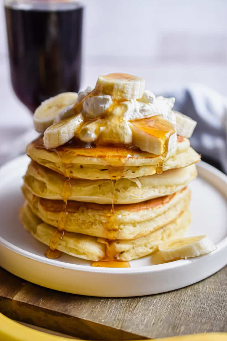 the 4 ingredient banana pancakes are stacked and topped with whipped cream