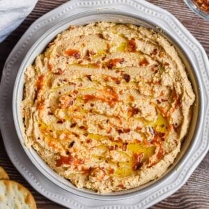 An overhead shot of the bowl of spicy hummus surrounded by crackers.