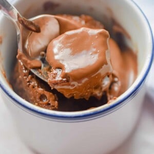 A spoon is lifting the Nutella Mug cake out of the mug.