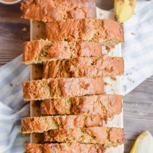 The banana bread without butter is on a cutting board and cutting into pieces.