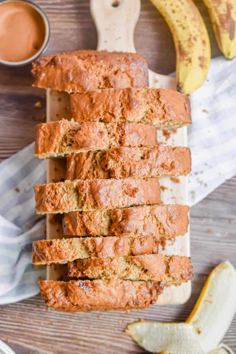 The banana bread without butter is on a cutting board and cutting into pieces.