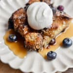 A portion of the french toast blueberry casserole is on a fluted plate.