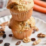 Two carrot cake muffins are stacked on top of each other.