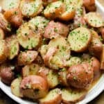 A plate of Instant Pot German Potato Salad is on a cutting board.