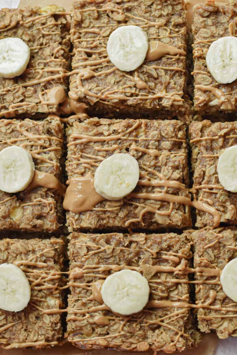 Nine 3 ingredient banana oatmeal bars are topped with a slice of banana.