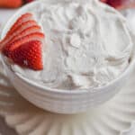 The 3 ingredient strawberry fluff dip is in a large bowl with strawberries surrounding it.