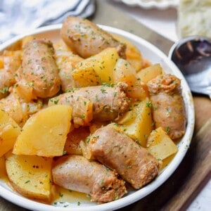 The Instant Pot Sausage and Potatoes are on a plate on a cutting board.