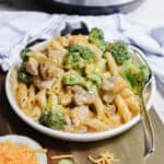 The Instant Pot Chicken Broccoli Pasta is on a plate on a cutting board.