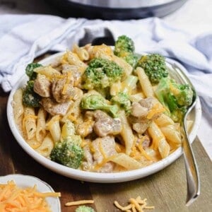 The Instant Pot Chicken Broccoli Pasta is on a plate on a cutting board.