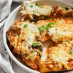 The Instant Pot Chicken Parmesan is on a circle plate topped with basil.
