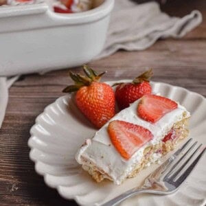 A slice of the strawberry icebox cake is on a fluted plate.