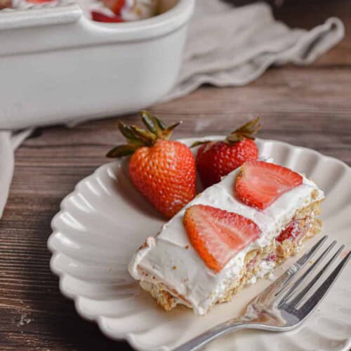 A slice of the strawberry icebox cake is on a fluted plate.
