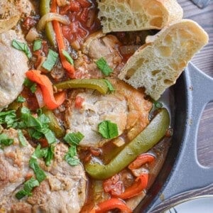 The texture of the chicken and cooked vegetables are shown with the oven baked chicken cacciatore in a large pan.