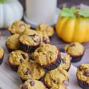 The mini pumpkin muffins are piled on a cutting board.