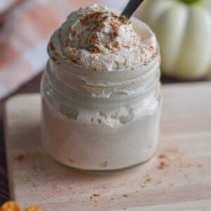 A spoon is in the mason jar with the pumpkin mousse.