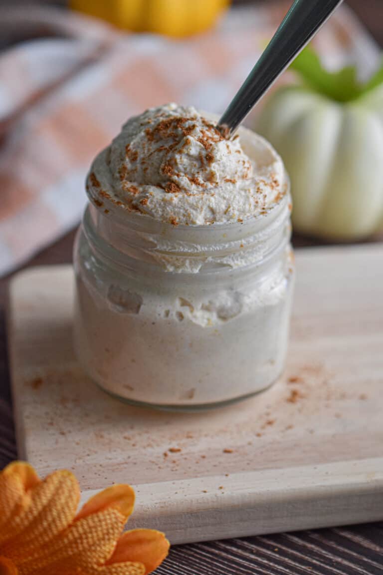 A spoon is in the mason jar with the pumpkin mousse.
