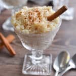 Two glasses of rice pudding are shown with spoons.