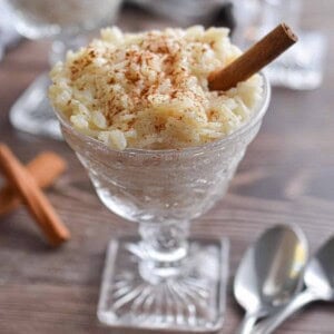 Two glasses of rice pudding are shown with spoons.