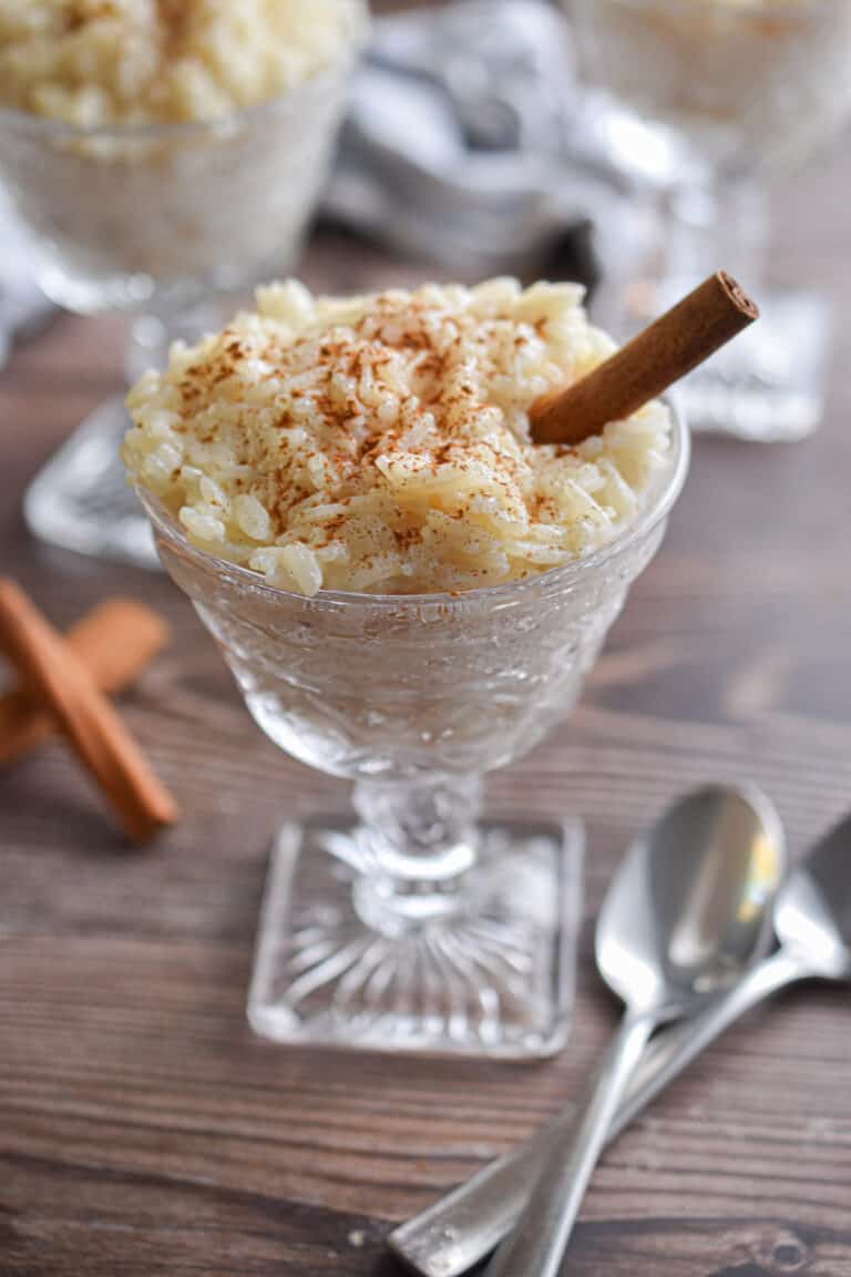 Two glasses of rice pudding are shown with spoons.