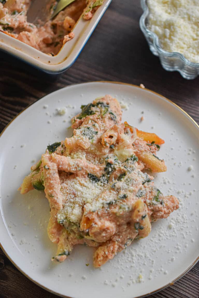 The meatless baked ziti is covered in parmesan cheese on a plate.