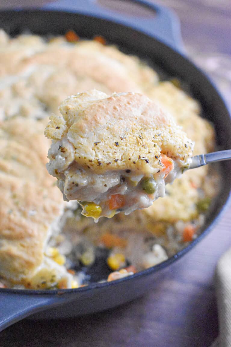 The turkey pot pie with bisquick is lifted out of the pan and held with a spoon.