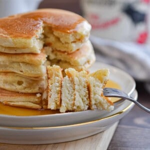 A fork is holding a piece of the stack of Bisquick pancakes no eggs.