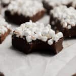 A piece of hot cocoa fudge has a bite out of it.