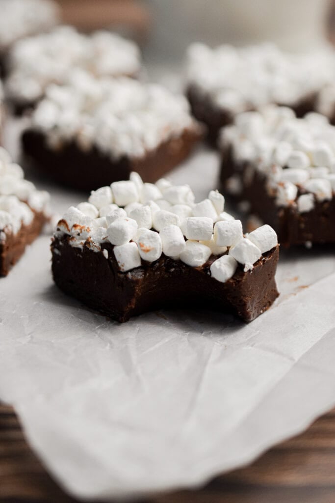 A piece of hot cocoa fudge has a bite out of it.