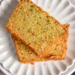 Two slices of zucchini bread with self rising flour are on a fluted plate.