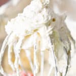 The 3 ingredient cream cheese frosting is on a wire whisk attachment.
