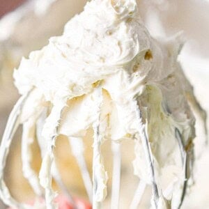 The 3 ingredient cream cheese frosting is on a wire whisk attachment.