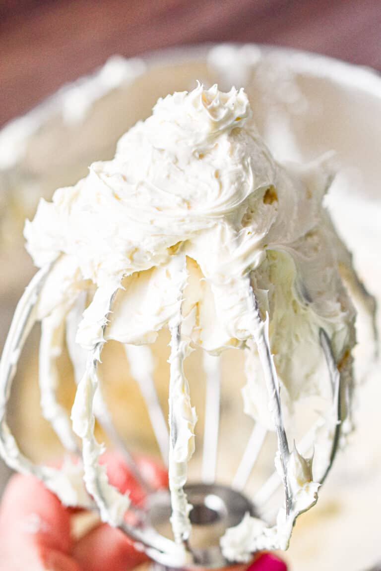 The 3 ingredient cream cheese frosting is on a wire whisk attachment.